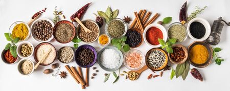Various dry spices in small bowls and raw herbs flat lay on white background. Top view,の写真素材