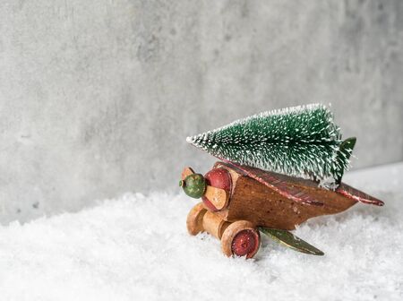 Christmas composition with a wooden vintage plane carrying a Christmas tree for a holidayの写真素材