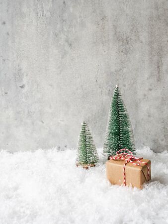 Christmas or New Year composition - two trees of different sizes and a big gift in the snowの写真素材
