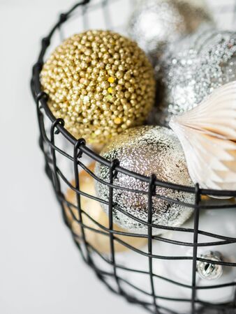A metal wicker basket with various gold and silver Christmas balls. Selective focusの写真素材