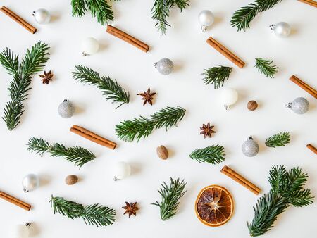 Flat lay creative Christmas vibrant composition with fir branches, Christmas decorations and spices on white background. Top viewの写真素材