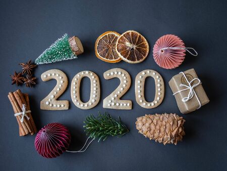 Ginger biscuits of the form of numbers and 2020 new year ginger cookies and Christmas decor on dark...