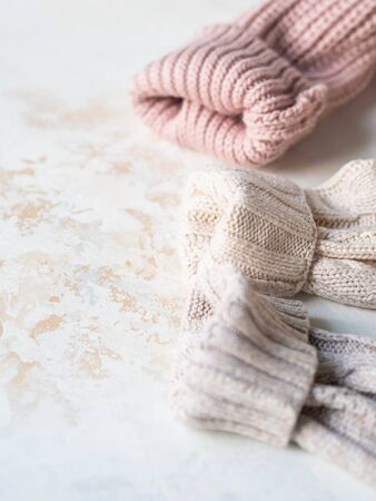 Sleeves of three of warm different knitted woolen sweaters pastel shades beige textured background.の写真素材