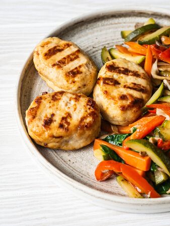 Turkey cutlets grill, vegetables steer fry on plate on wood board table.の写真素材