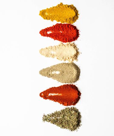 Various dry spices in heaps on a whiteの写真素材