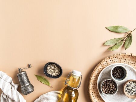 Flat lay of small bowls various dry spices, wood kitchen utensils, olive oil in glass bottle on a beige background. Top view. copy spaceの写真素材