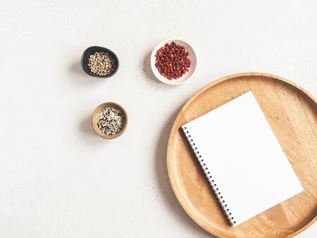 Kitchen notepad mockup for culinary text on wood tray and spices on a light background. Top view. Copy spaceの写真素材