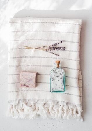 Lavender soap, flavored salt and a bouquet of dry lavender on cotton towel.の写真素材
