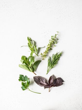 Bunches of fresh raw herbs - mint, thyme, dill, parsley, basil and tarragon on a textured background. Top view. Copy spaceの写真素材