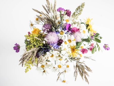 Multicolored diverse wildflowers bouquet on white background. Top viewの写真素材