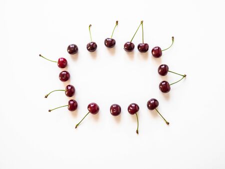 Frame of large ripe cherry berries on white background. Natural summer food background. Creative food summer layout. top view.の写真素材