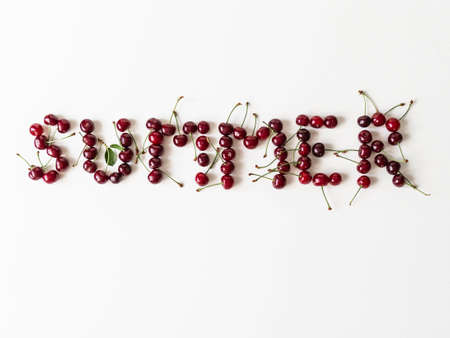 Word summer created from fresh ripe cherry berry on white background. Top view. copy spaceの写真素材
