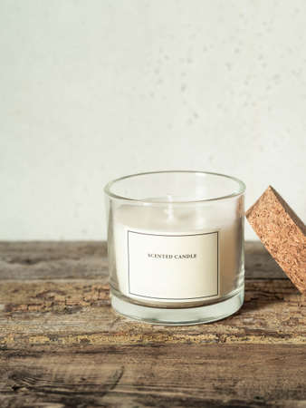 Glass candle white aromatic mockup on old plank table on gray background. copy spaceの写真素材