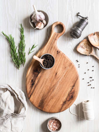 Kitchen cooking flat lay. Various food ingredients, kitchen utensils and wood cutting board for placing your text on a light wood board background. Top view.の写真素材