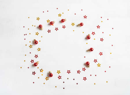 Christmas or new year frame of stars confetti and red christmas balls on white texture background. top view. Copy space. flat layの写真素材