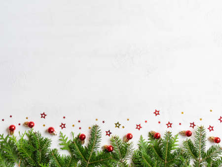 Christmas and New year border with fir branches and christmas balls on white texture background. Flat lay, top view, copy spaceの写真素材