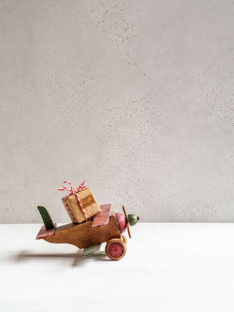 Christmas composition wooden vintage plane carrying Christmas gift for holiday. Copy space. Front view. holiday delivery conceptの写真素材