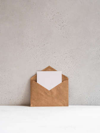 Open kraft envelope and empty postcard near the gray wall, front view. Copy spaceの写真素材