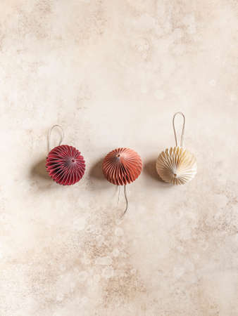 Multicolored pastel paper origami Christmas decorations on brown background. Top view. Copy spaceの写真素材