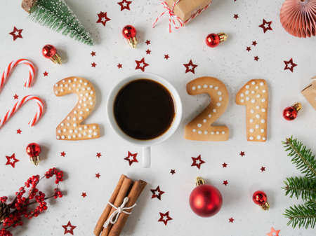 Gingerbread cookies in the form of numbers, gingerbread New Year 2021, mug of coffee instead of scratch and festive decor on gray background. Top view. Flat layの写真素材