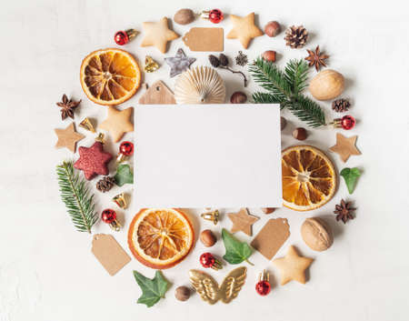 Round knolling composition of various items and food related to Christmas and blank postcard on white textured mackground. Top view. Copy space. Flat layの写真素材
