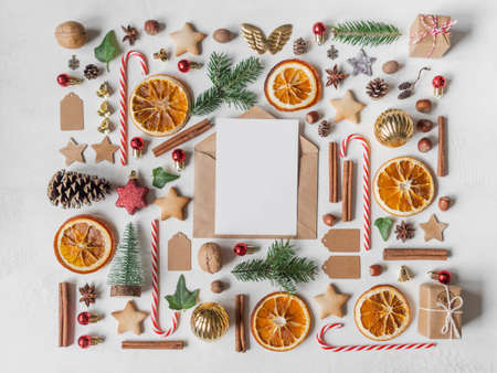 Multicolored Christmas knolling and open envelope with blank postcard for text on light textured background. Flat lay. Top viewの写真素材