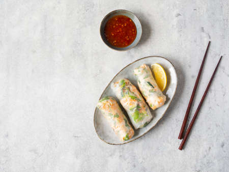 Vietnamese spring rolls with salad, sauce, crab, and noodles on an oval plate with spicy sauce. top view. copy spaceの写真素材