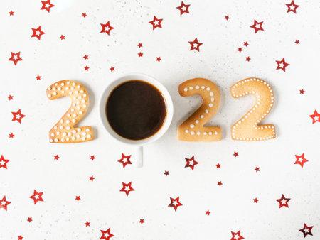 Gingerbread cookies in the form of numbers, gingerbread New Year 2022 and mug of coffee instead of...