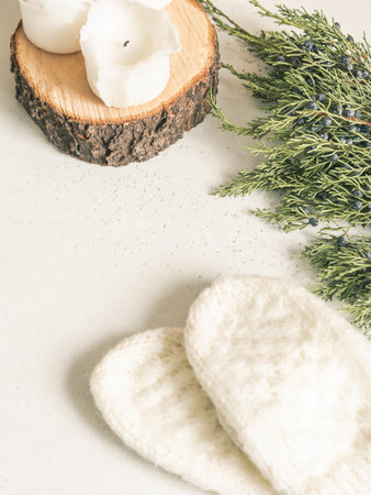 Winter compositions of knitted mittens, candles and green branch on white background. Top view. copy spaceの写真素材