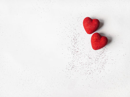 Two red shiny hearts on a gray background. Valentine's day concept. Top view. Copy space. Selective focusの写真素材