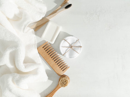 Various eco frendly items - toothbrushes, hairbrush, reusable cotton pads white towel and facial brush on white background. Top view. Copy spaceの写真素材