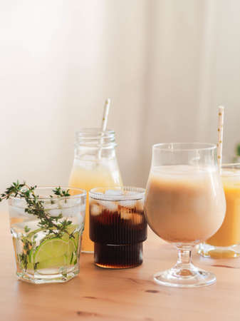 Various refreshing non-alcoholic drinks in glasses with ice. Fruit juice, lemonades, iced coffee, smoothies on wood table. Copy space. Front viewの写真素材