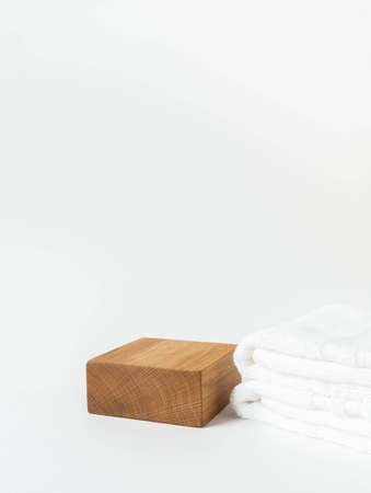 Empty wood cube podium for products presentation. Display stand and white towels on white background. Front view. Copy space.の写真素材