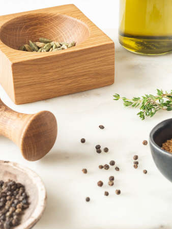 Herbs and spices cooking on marble table. Wood mortar and pastle and various spices and herbs. Front view. Copy spaceの写真素材