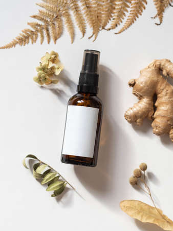 Organic natural product - oils, various dry plants and glass bottle mockup on white background Herbal alternative medicine and aromatherapy. Top view. Copy space. Selective focusの写真素材