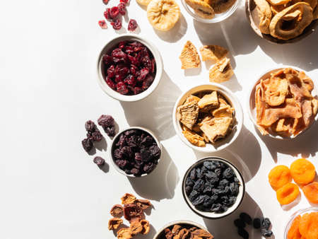 Various dried fruits and berries. Flat lay dried or sun-dried berries and fruits in bowlsの写真素材