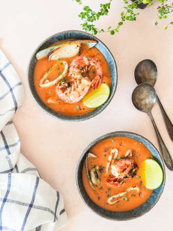 Seafood tomato soup in blue ceramic bowls. Mediterranean cuisine. Close up. Top view