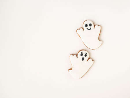 Minimal Halloween composition with gingerbread cookies - ghosts on white background. Halloween concept. Top view. Copy spaceの写真素材