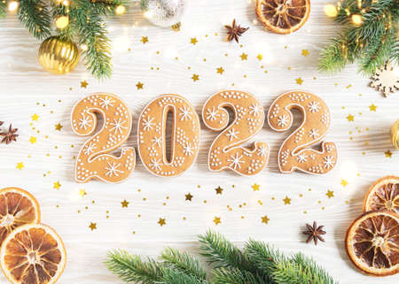Gingerbread cookies in the form of numbers, gingerbread New Year 2022 and season festive decor on white wood background. Top view. Flat layの写真素材