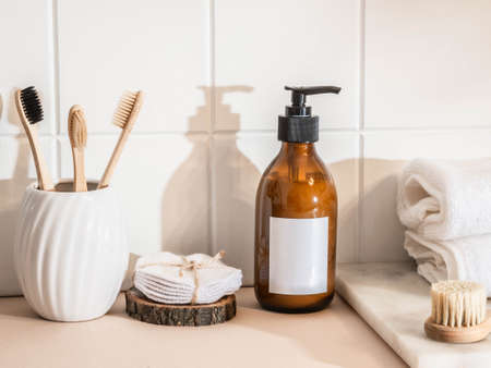 Mockup for care cosmetics products - amber bottle skin care with white labels, bamboo toothbrush and...