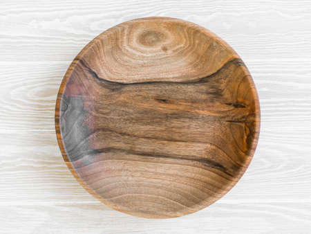 Round wooden craft plate mockup for eco, food or beauty product on white wood table. Top view. Copy spaceの写真素材