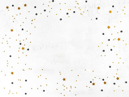Christmas composition. Golden confetti and black sequins frame on white background. Christmas, New Year, holiday concept. Flat lay, top view, copy spaceの写真素材