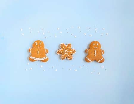 Happy New Year or Christmas card, gingerbread couple - man and woman and snowflake on blue background. Happy family concept Top view. Flat layの写真素材