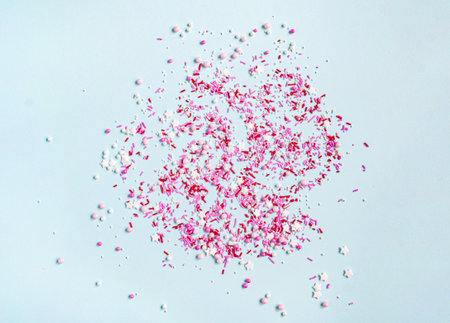 Colored sugar sprinkles background. Sugar sprinkle dots, decoration for cake and bakery, lot of sprinkles on blue background. Top view. Flat layの写真素材