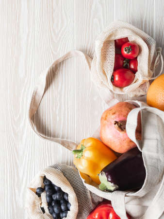 Fresh vegetables and fruits in eco cotton bags on table in the kitchen. Zero waste shopping concept. Top view. Copy space. Flat layの写真素材