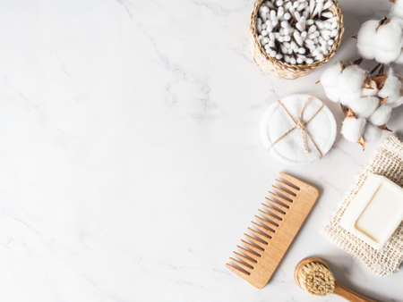 Zero waste personal bathroom accessories. Wooden brush, soap, toothbrush, cotton towel on marble background. Free plastic concept. Eco-friendly home care. Top view. Copy spaceの写真素材