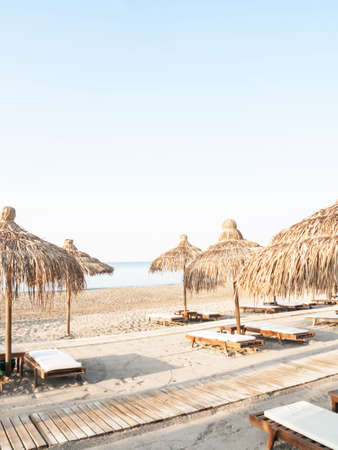 Straw umbrellas on empty seaside beach. Beach holiday conceptの写真素材