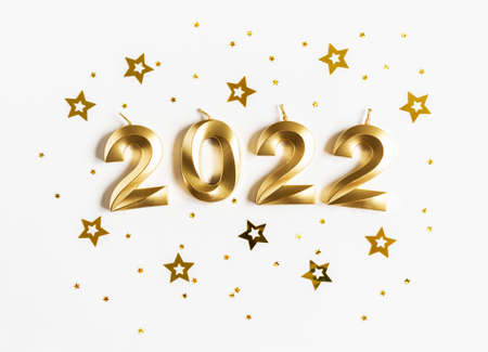 Greeting card - happy new year with numbers 2022, gold stars glitter on white background. Minimal holiday concept. Top view. Flat layの写真素材