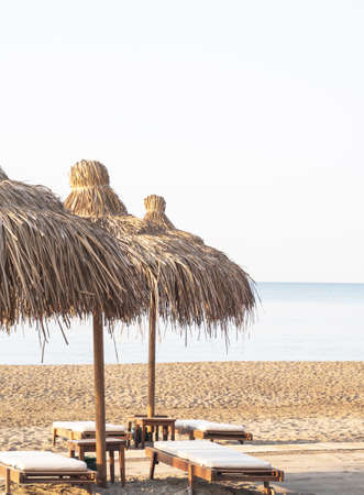 Straw umbrellas on empty seaside beach. Beach holiday conceptの写真素材