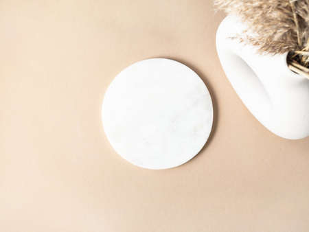 White marble round podium on beige background, platform for product display and decoration. Blank for mockup design. Top view. Copy spaceの写真素材